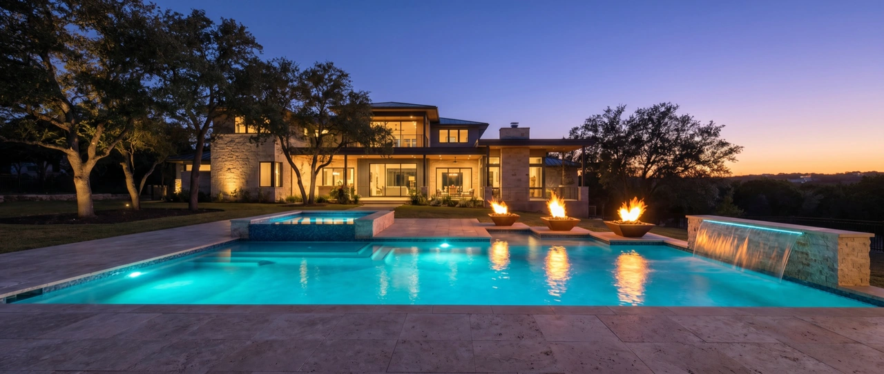 Custom pool and spa with fire bowls at dusk